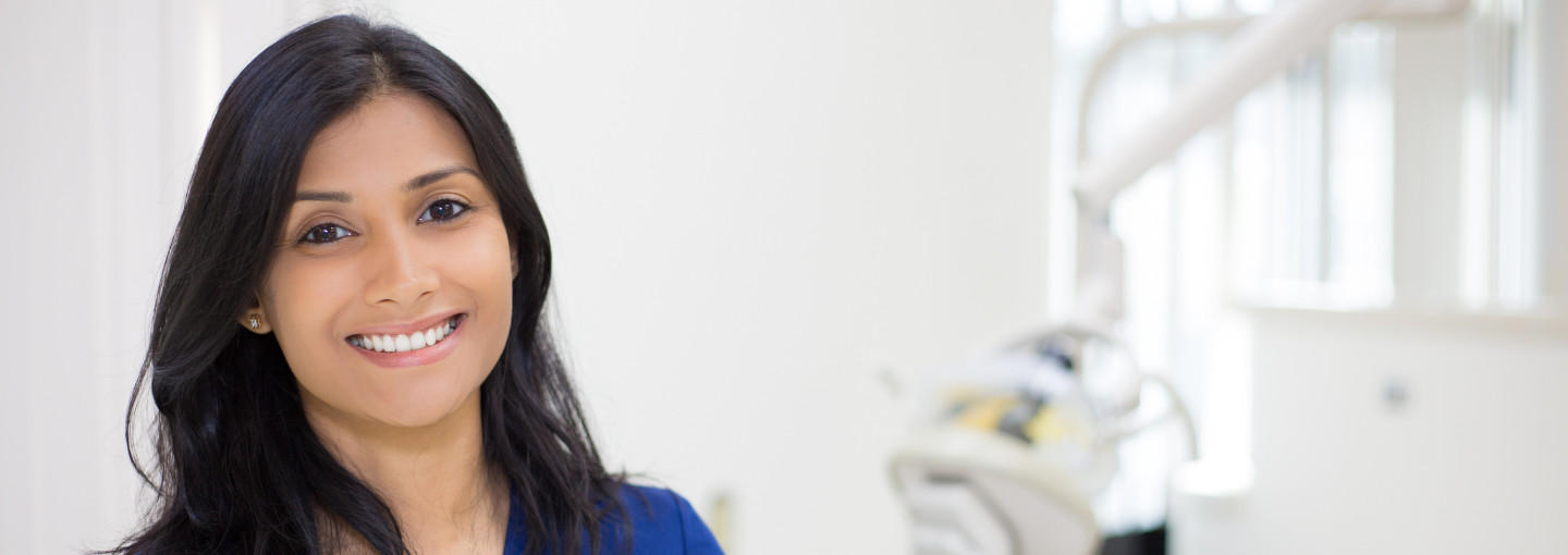 A female dentist smiling in her dental clinic