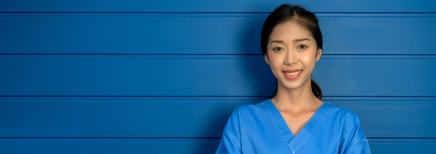 Young student dentists standing with bright blue wall behind