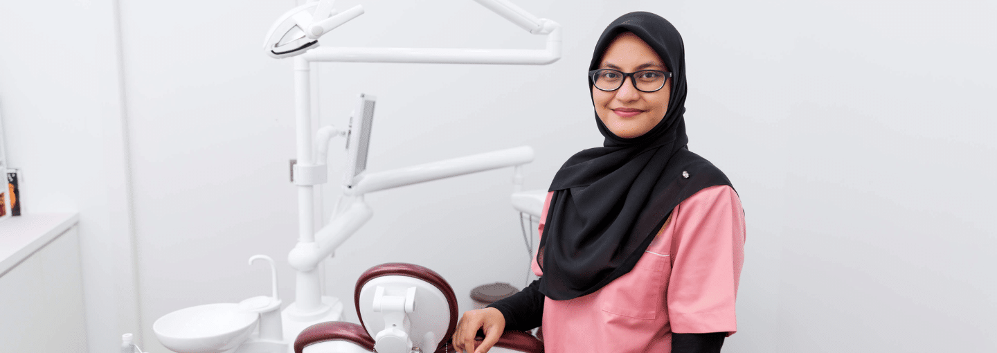 Female dentist with hijab standing in dental clinic